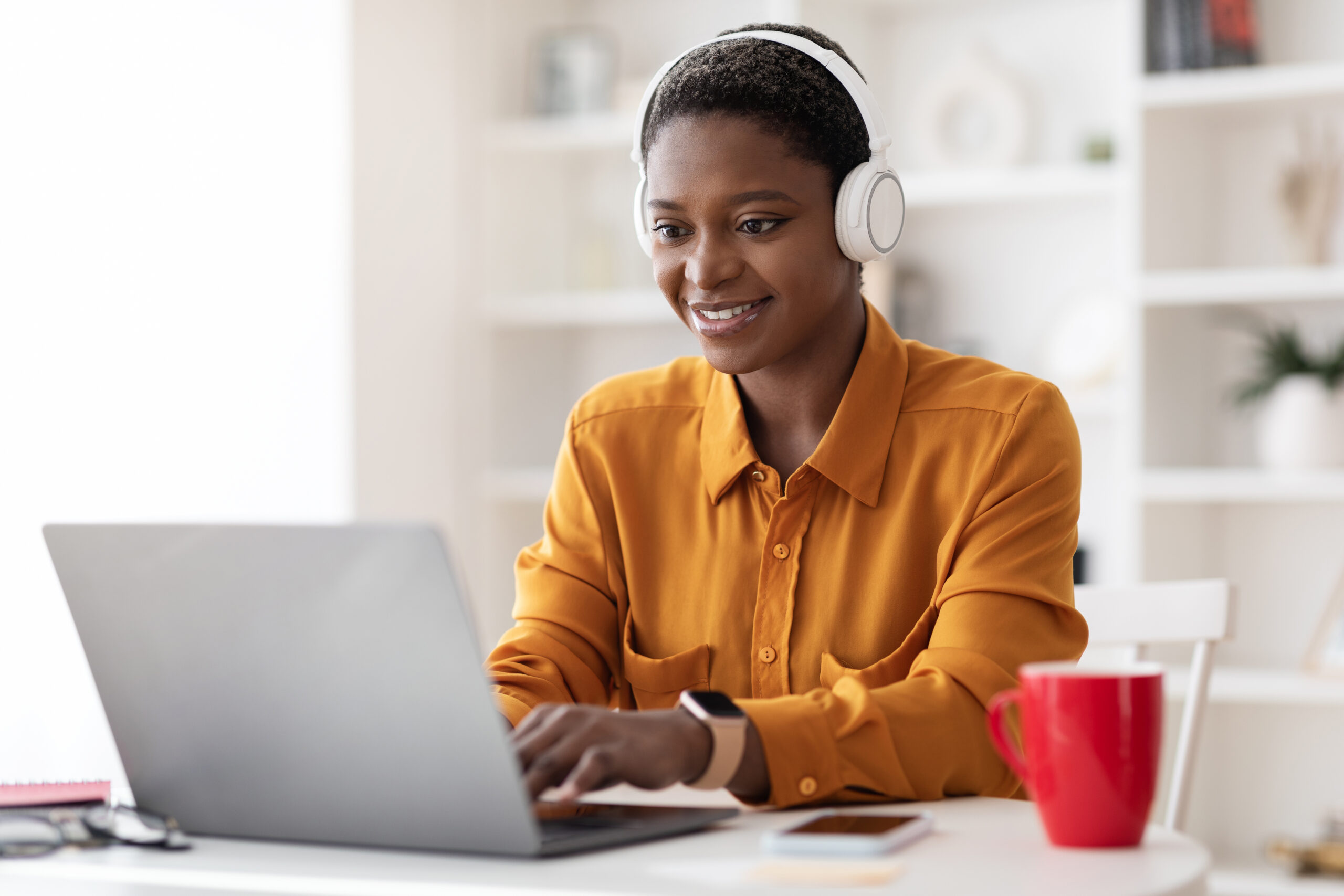 a woman using a computer with headphones on