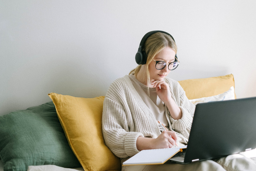 A woman relaxing while doing work on her computer