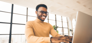 a man smiling and using a computer