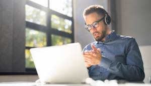 a man wearing headphones and using a computer